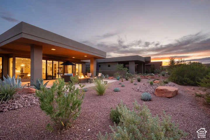 Expansive patio with a gas fire pit, covered outdoor living space, and desert landscaping