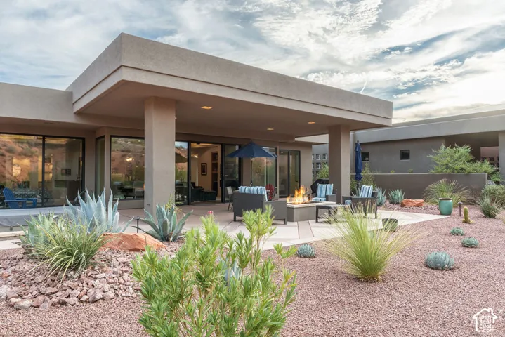 Expansive covered patio with recessed lighting, large format sliding glass doors, and a built-in fire pit