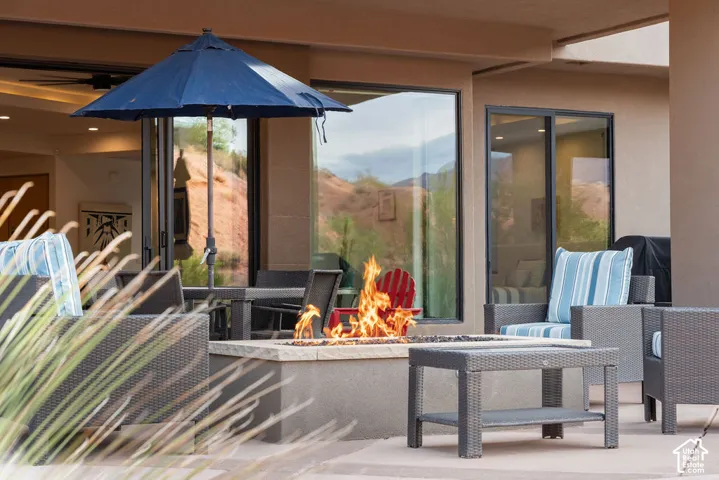 Patio with a built-in fire pit, expansive glass sliding doors, and a covered outdoor area