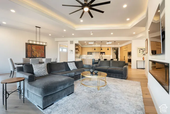 Open concept living area with wood-finish flooring, recessed lighting, and a linear electric fireplace