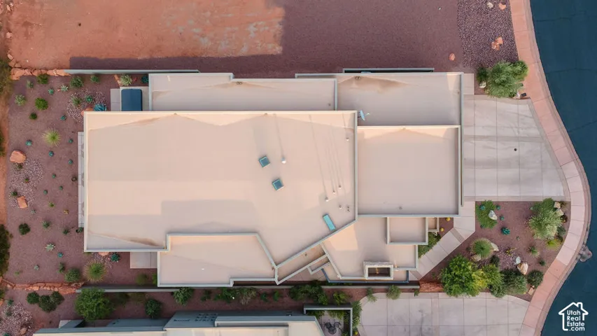 Flat roof design, multiple skylights, integrated spa, paved driveway, and desert-adapted landscaping