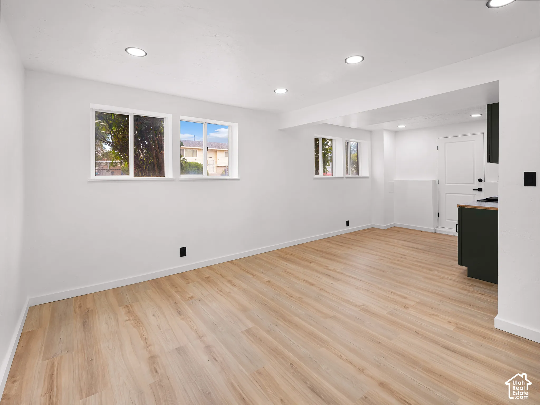Recessed lighting illuminates the wood-finish flooring