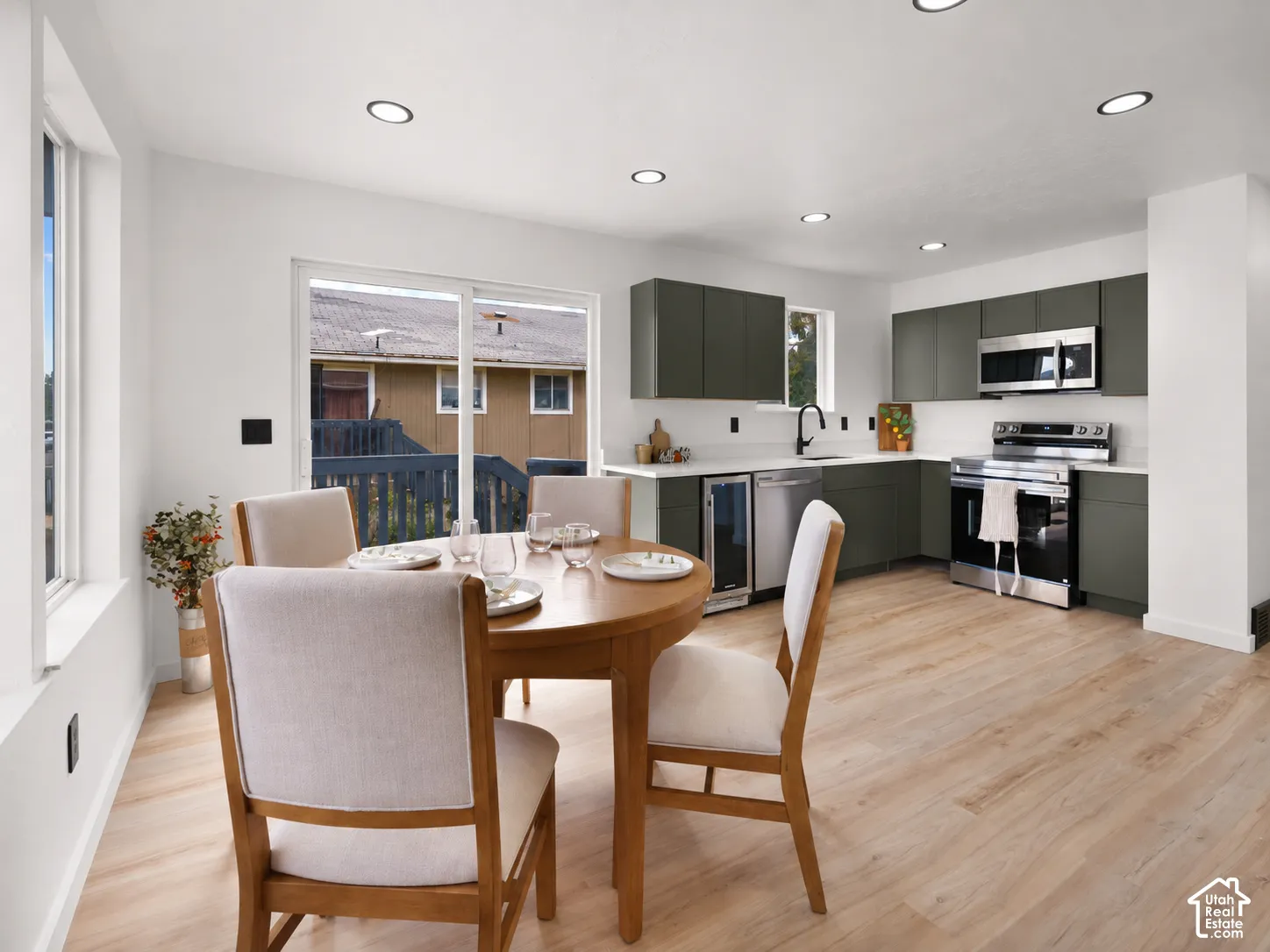 Open-concept living space with wood-finish flooring, recessed lighting, modern cabinetry, and stainless steel appliances