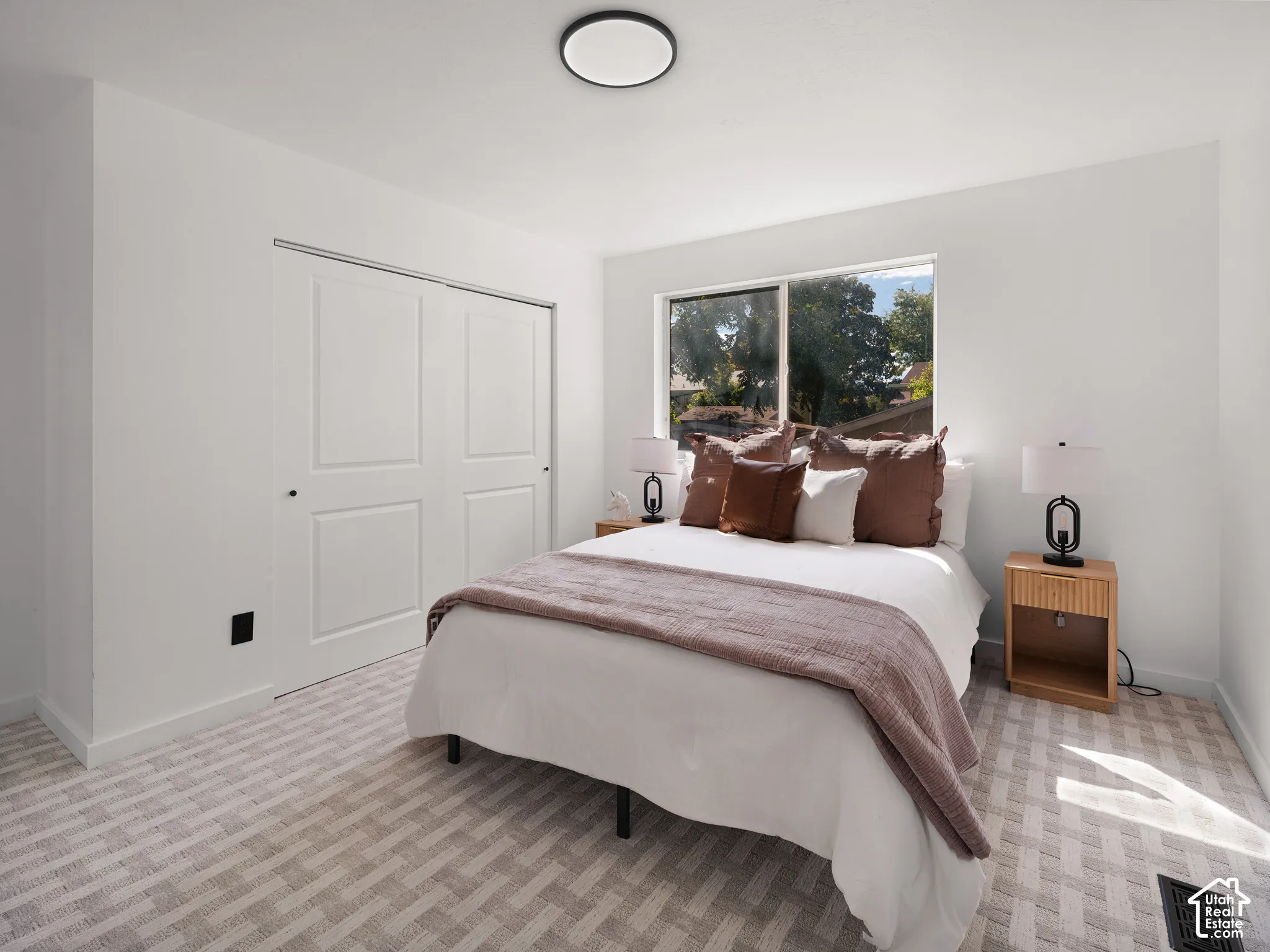 Recessed lighting, large window, built-in bi-fold closet doors, and patterned carpet flooring