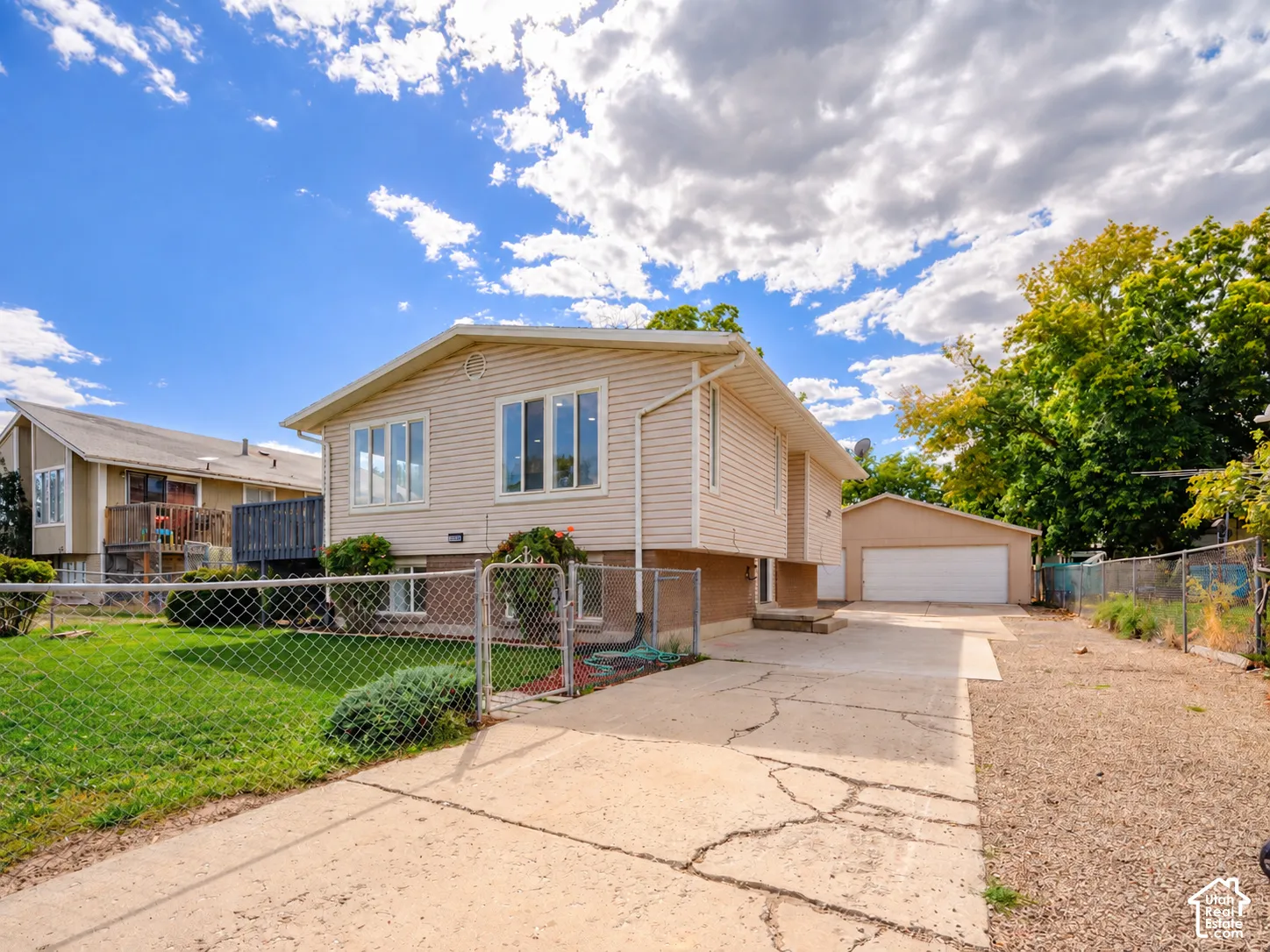 Cream-colored siding exterior with a concrete driveway and an attached garage
