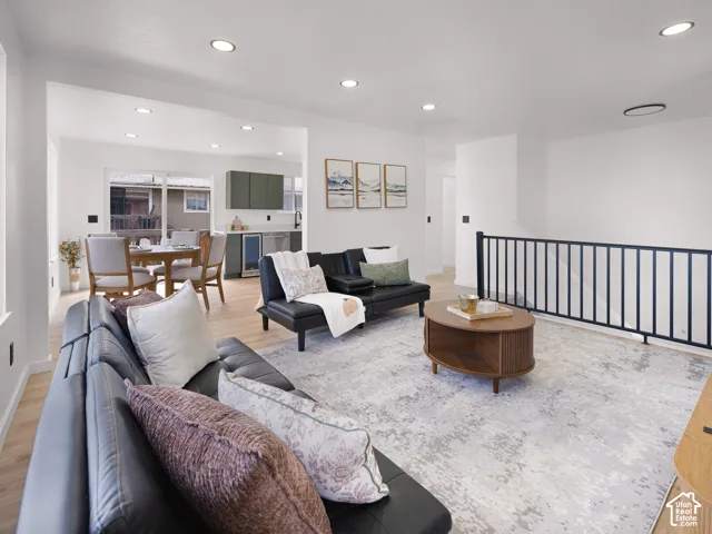 Recessed lighting illuminates an open-concept living area with wood-finish flooring