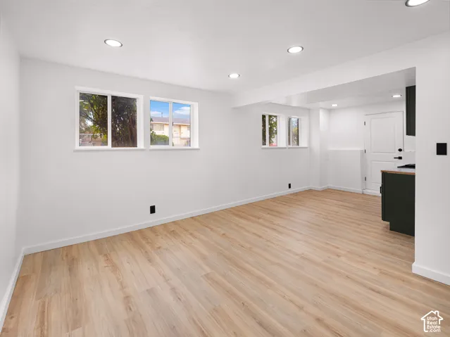 Recessed lighting illuminates the wood-finish flooring