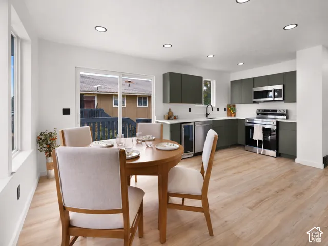Open-concept living space with wood-finish flooring, recessed lighting, modern cabinetry, and stainless steel appliances