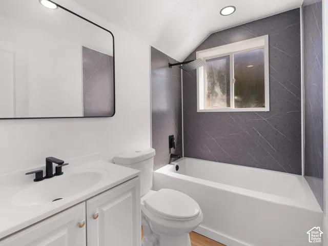 Bathroom featuring white vanity with integrated sink, matte black faucet, and a wall-mounted rectangular mirror