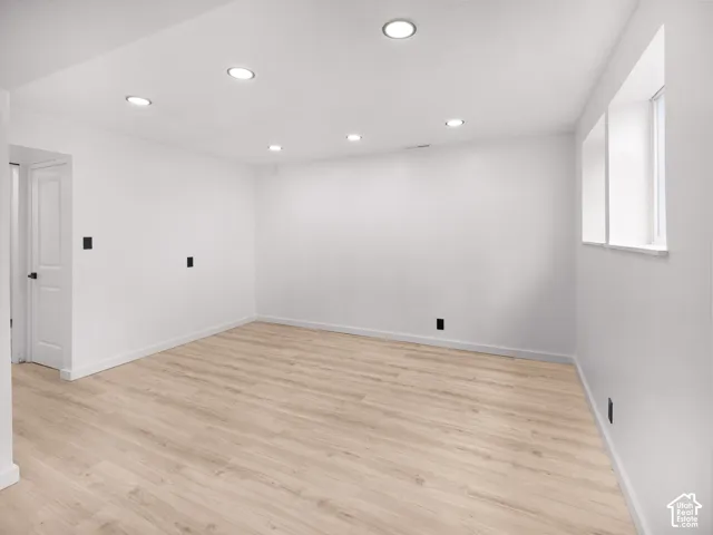 Recessed ceiling lighting, wood-finish flooring, white walls, and a window