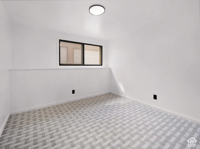 Neutral wall finishes, patterned carpeting, and recessed lighting