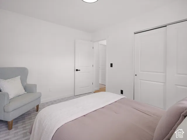 White painted walls, two-panel interior door with black hardware, and sliding two-panel closet doors