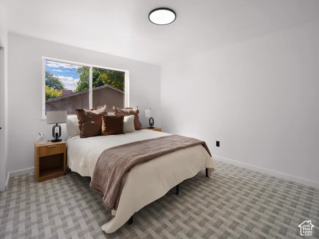 White walls, patterned carpet flooring, and a large window