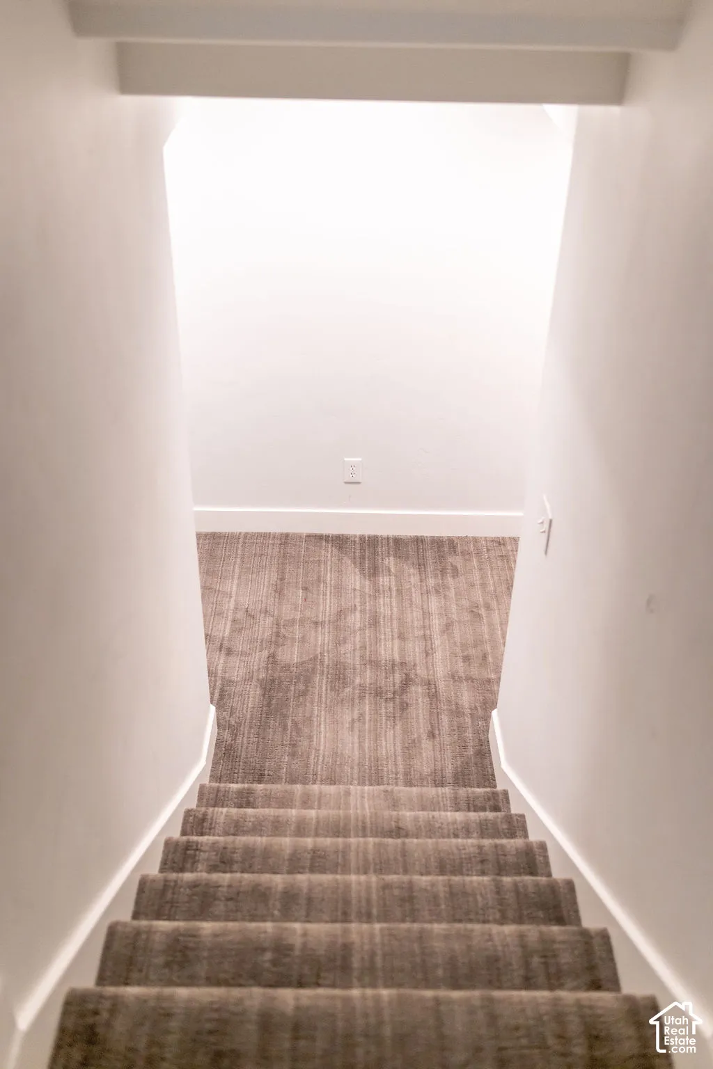 Staircase featuring neutral carpeting and white wall finishes