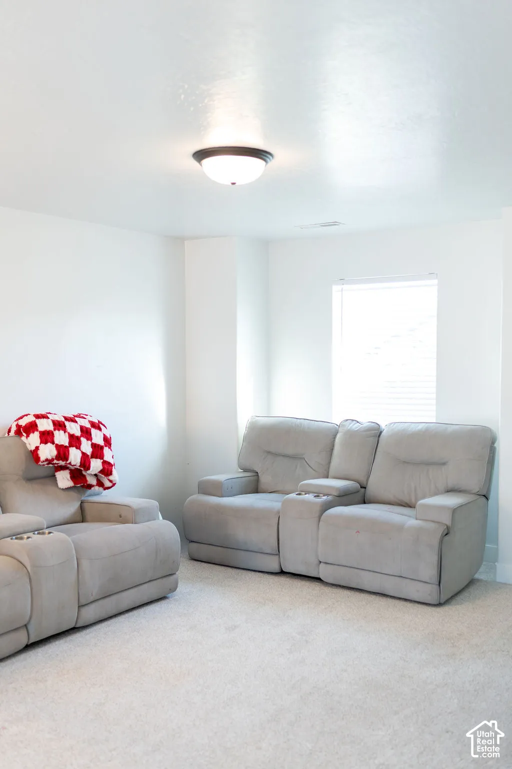 Neutral wall paint, ceiling-mounted light fixture, and carpeted flooring