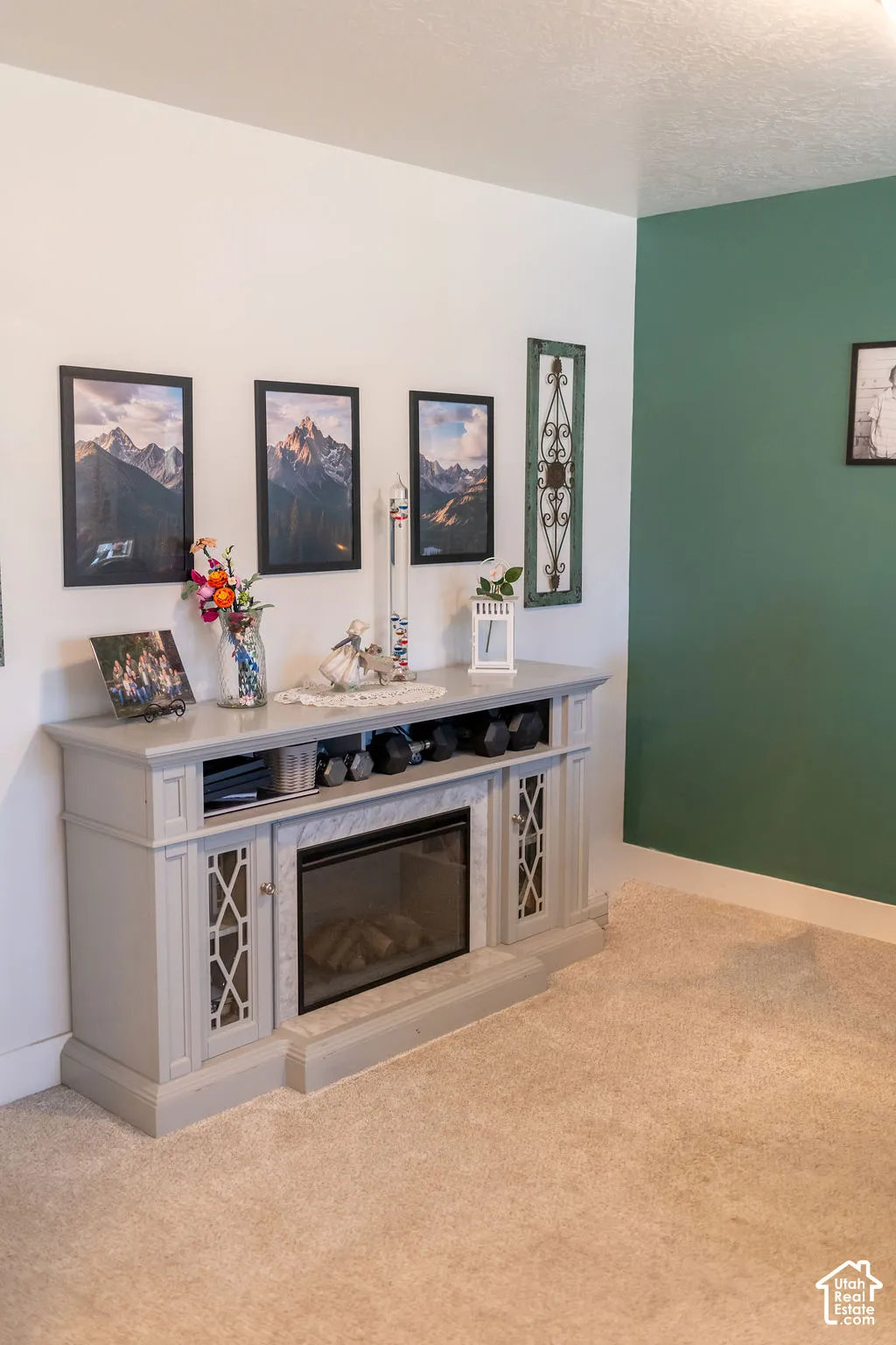 Electric fireplace with a light gray mantel, integrated cabinetry, and an inset firebox