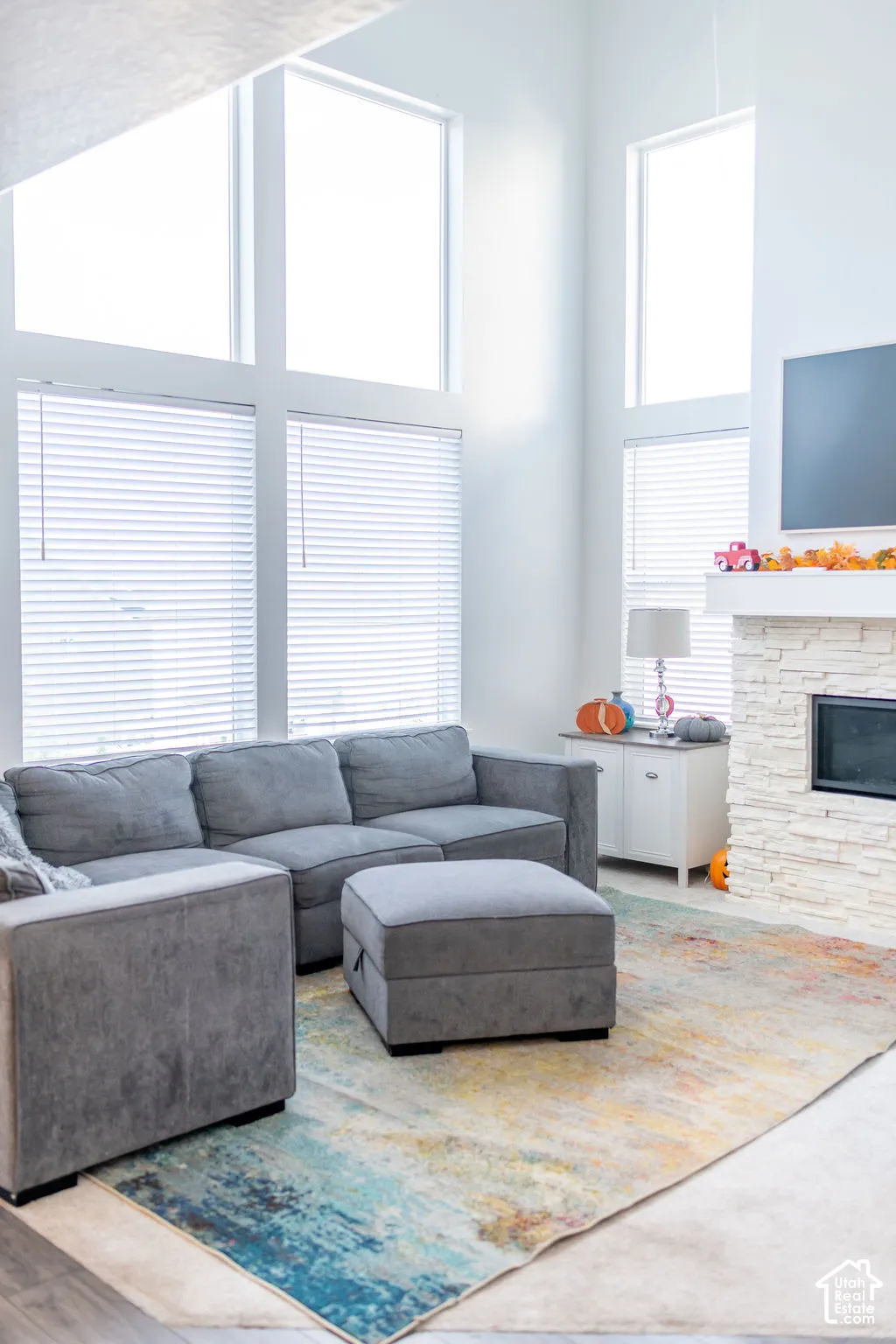 Vaulted ceilings, large windows, stone-clad fireplace, built-in fireplace, and wood-finish flooring