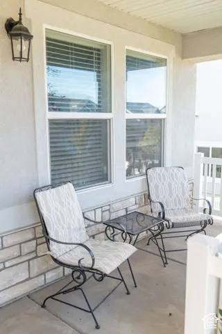 Covered porch with concrete flooring and stone veneer detailing