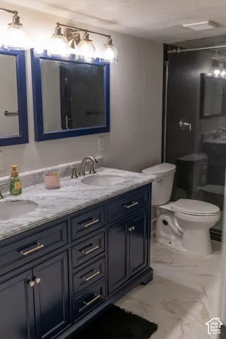 Dual-sink vanity with a light-toned countertop, dark-toned cabinetry, and satin nickel hardware