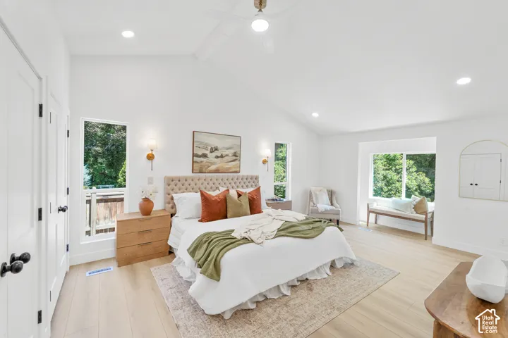 Vaulted ceilings, recessed lighting, wood-finish flooring, multiple windows, and a built-in window bench
