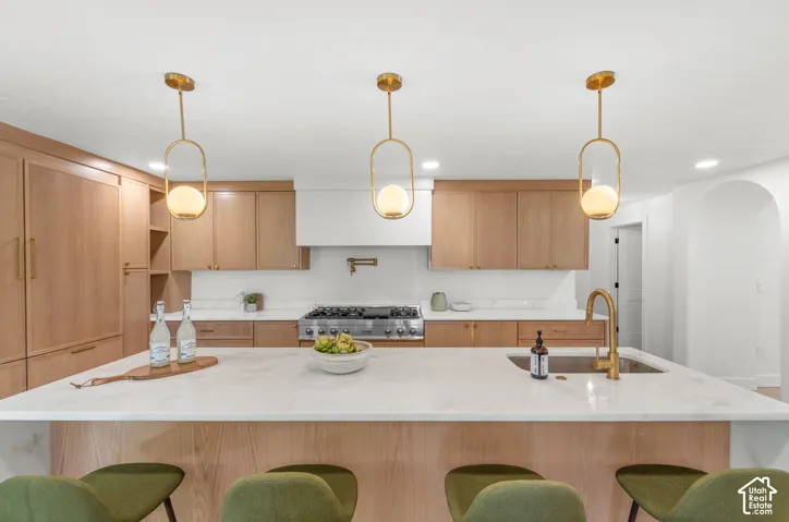 Wood-finish cabinetry complemented by a white range hood and a pot filler