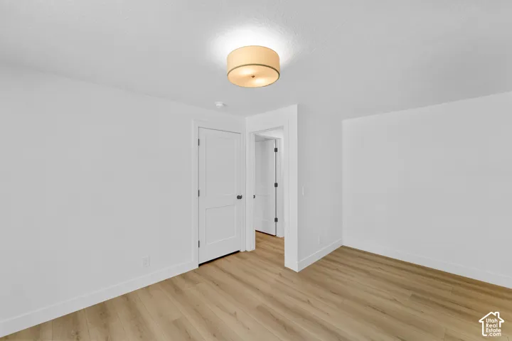 Wood-finish flooring, white walls, white trim, and a semi-flush mount ceiling light