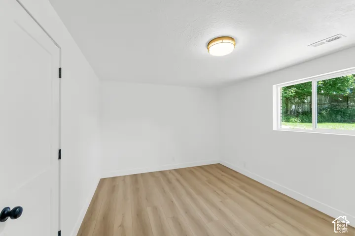 Wood-finish flooring, white walls, and a contemporary ceiling light fixture