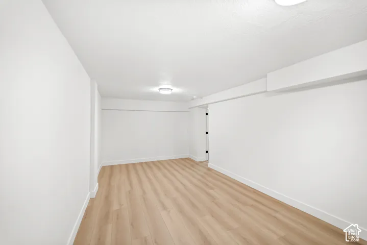 Recessed lighting fixtures illuminate wood-finish flooring