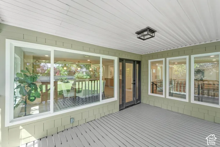 Covered patio with a planked ceiling, recessed lighting, and a dark-framed double door entry