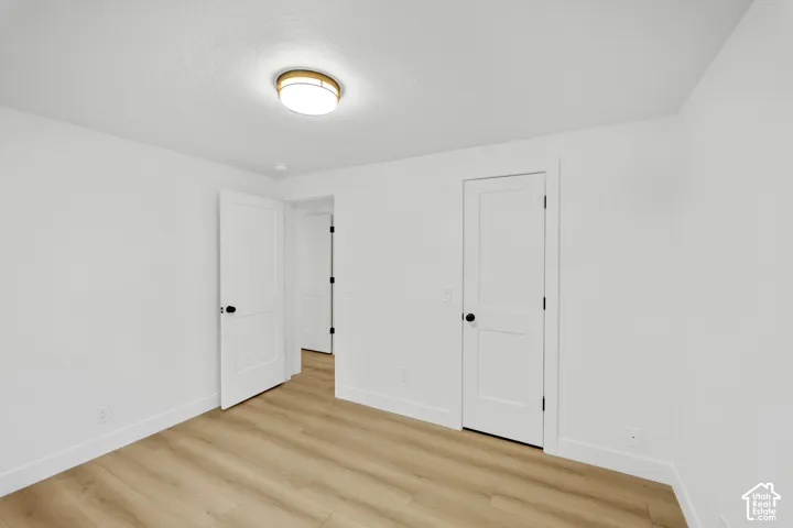 White interior walls, wood-finish flooring, and white trim