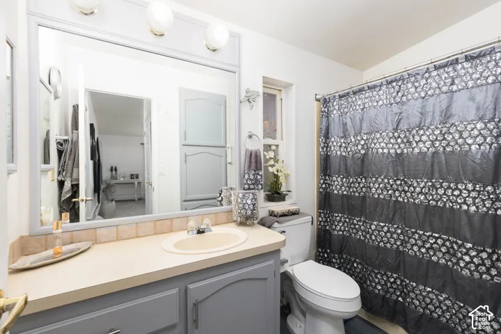 Vanity with integrated sink, light-toned countertop, and painted cabinetry