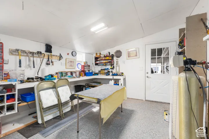 Utility room with a white panel door, built-in shelving, and overhead fluorescent lighting