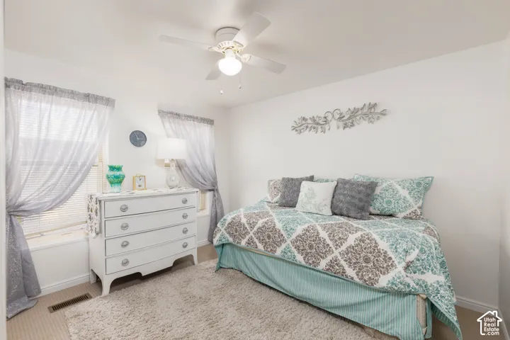 Neutral wall finishes, recessed window alcoves, ceiling fan light fixture, and carpeted flooring
