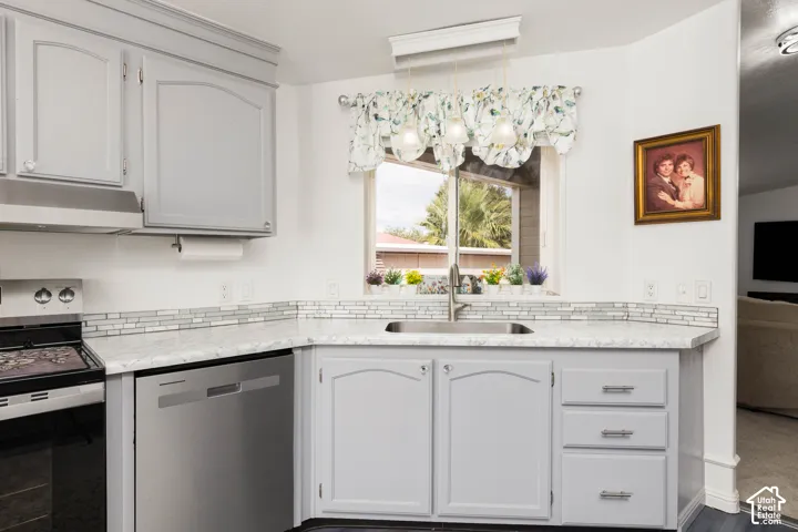 Gray cabinetry with brushed nickel hardware, stainless steel dishwasher, mosaic tile backsplash, composite countertops, and stainless steel sink