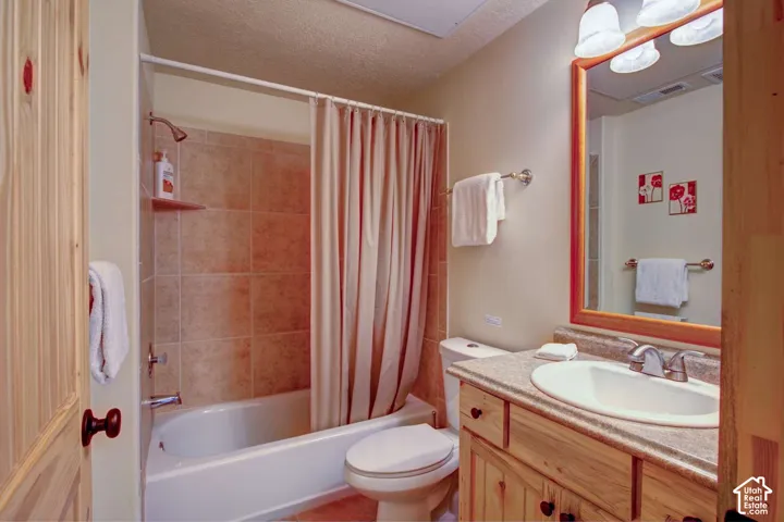 Tile-surround bathtub and shower combination with a wood-finish vanity and countertop