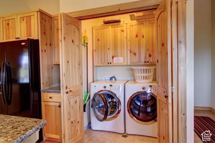 Built-in laundry appliances with wood-finish cabinetry and overhead storage