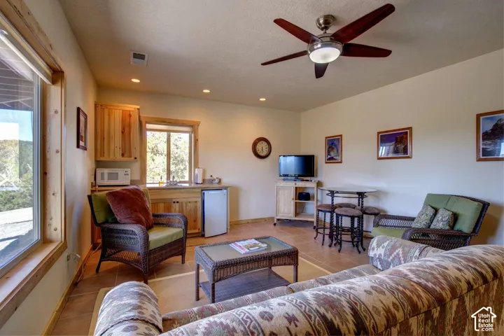 Recessed lighting, ceiling fan with light fixture, wood-finish flooring, built-in cabinetry, and integrated sink