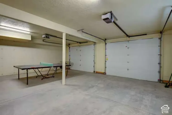 Two-car garage with concrete flooring, two overhead garage doors, and two garage door openers