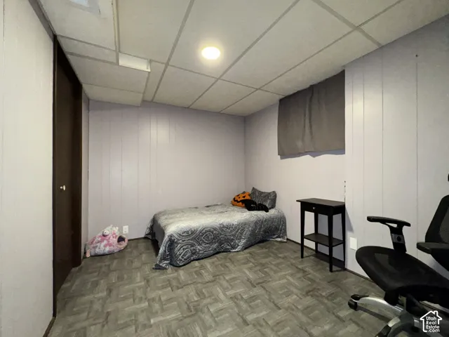Recessed lighting, wood-finish flooring, paneled walls, and a drop ceiling