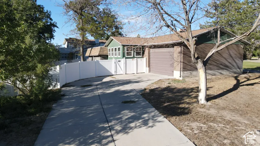 Concrete driveway leading to an attached garage with a brown door