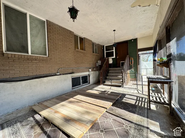 Brick exterior with white-framed windows, a covered entryway, and an exterior light fixture
