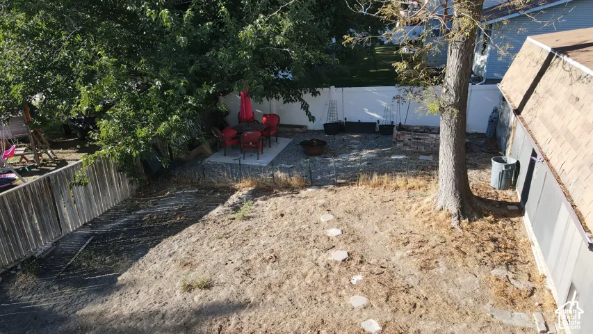 Patio with concrete slab, gravel surround, and a fire pit