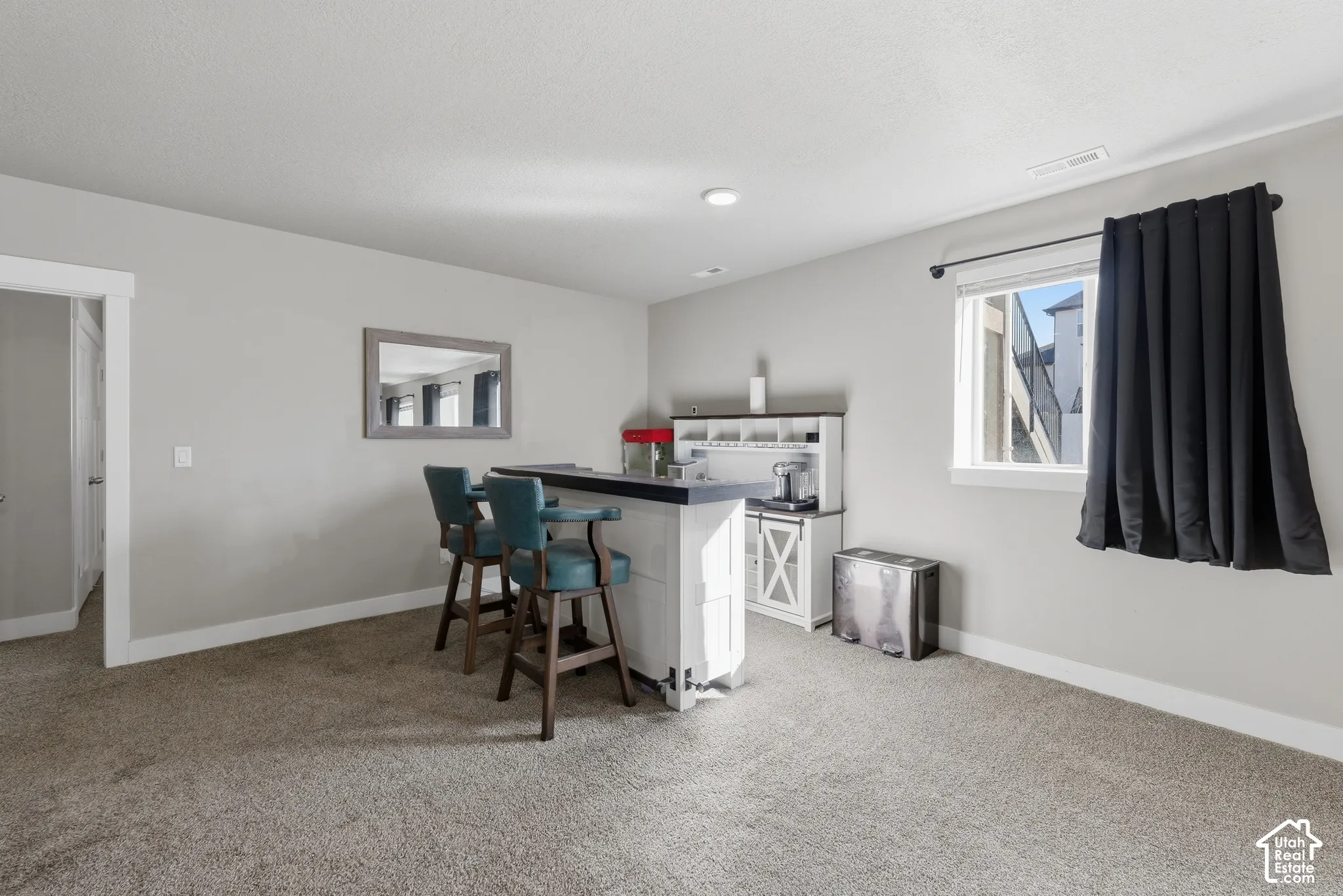 Neutral-toned interior featuring wall-to-wall carpeting, recessed lighting, and a window with custom-fit hardware