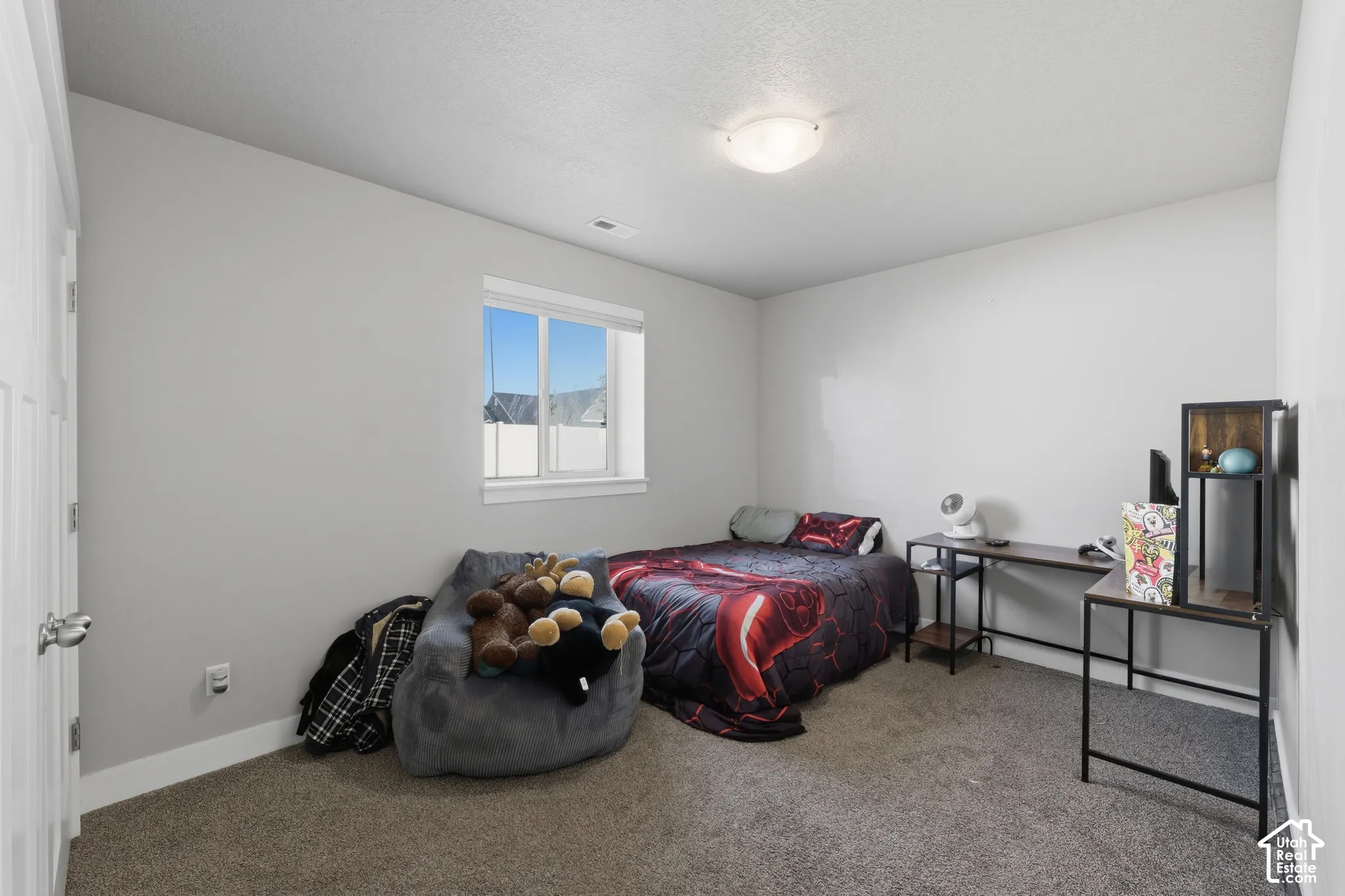 Neutral wall palette with carpeted flooring, a recessed window, and a central ceiling-mounted light fixture