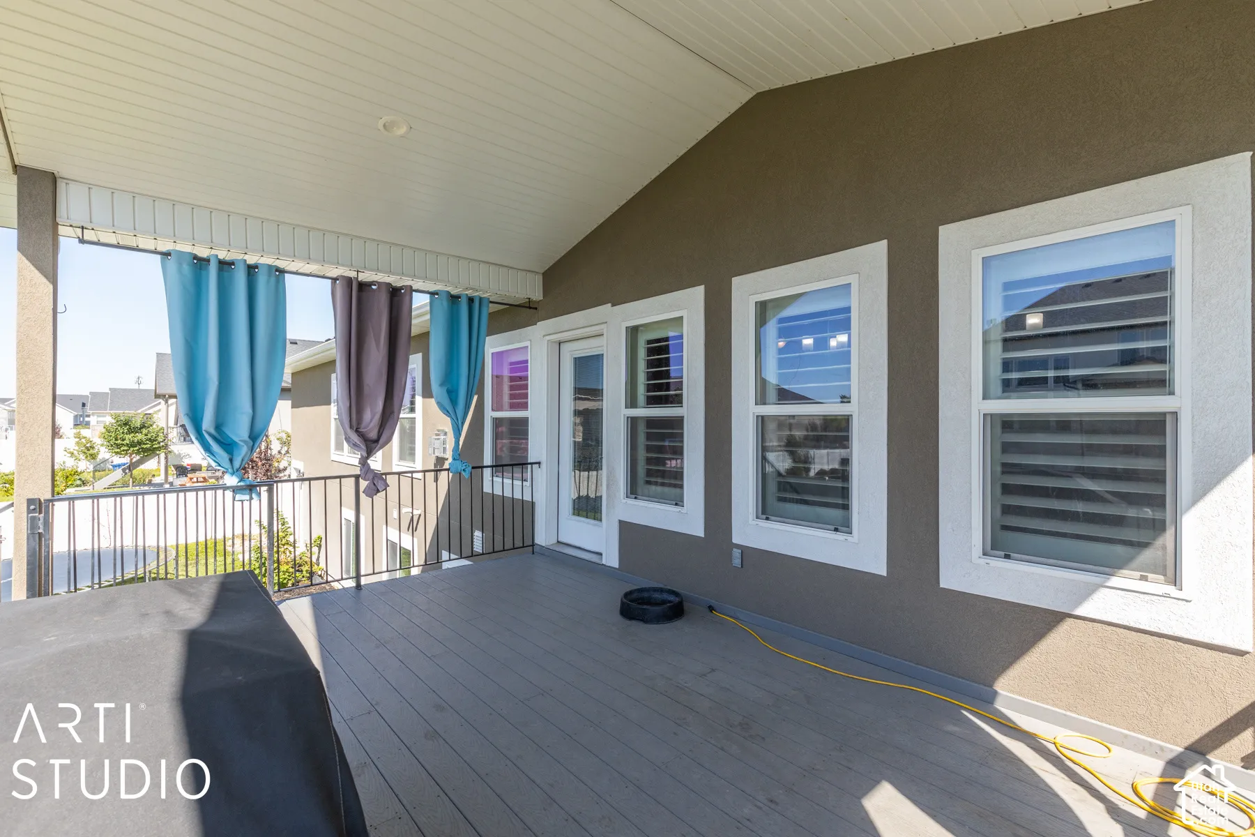 Covered outdoor patio with composite decking and black metal railings
