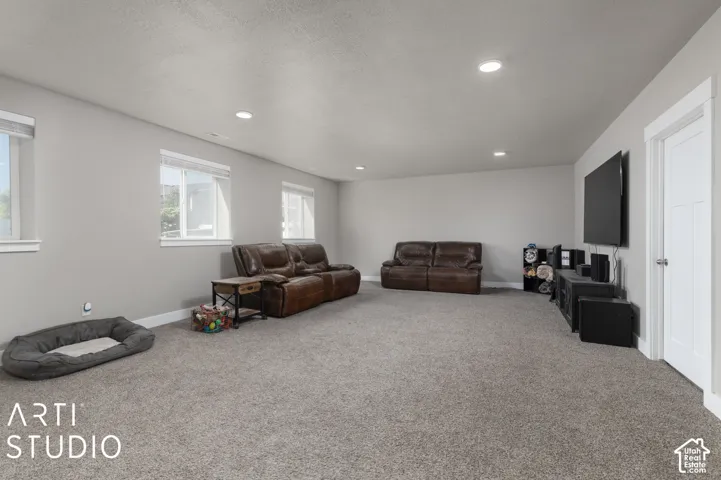 Expansive room with recessed lighting, light gray wall paint, and gray carpeting