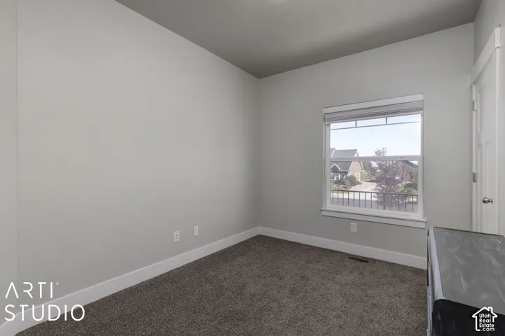 Neutral wall paint, plush carpet flooring, white trim, and a window with blinds