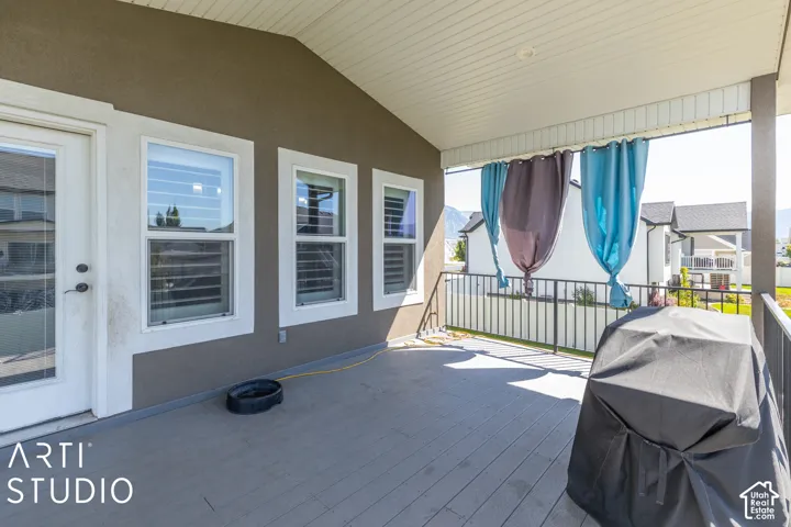 Covered outdoor patio featuring composite decking, a white railing, and exterior wall siding