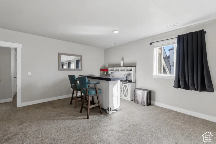Neutral-toned interior featuring wall-to-wall carpeting, recessed lighting, and a window with custom-fit hardware