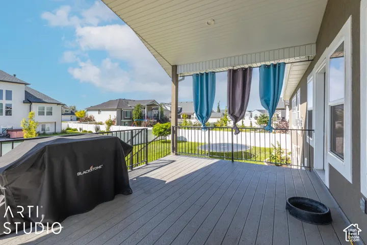 Covered deck featuring composite decking, black metal railings, and dual-pane windows